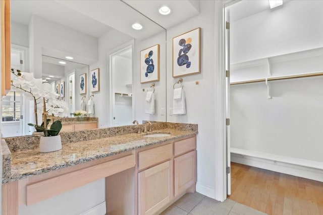 bathroom featuring recessed lighting, tile patterned flooring, a walk in closet, and vanity