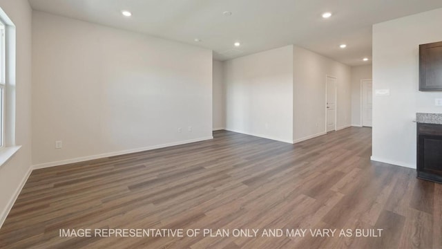 unfurnished living room featuring baseboards, dark wood-style flooring, and recessed lighting