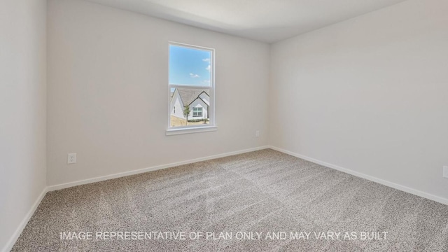 carpeted spare room featuring baseboards