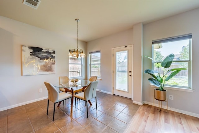 dining area with visible vents, a notable chandelier, baseboards, and tile patterned floors