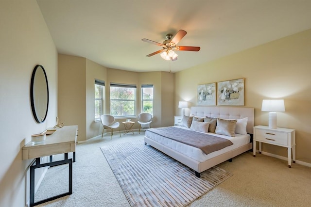 bedroom featuring ceiling fan, baseboards, and light colored carpet