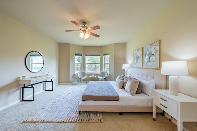 bedroom with light carpet, baseboards, and a ceiling fan