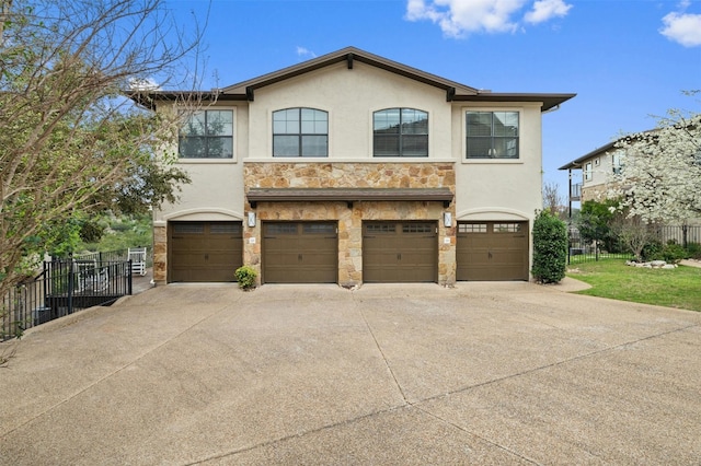 view of front facade with a garage, stone siding, driveway, and stucco siding