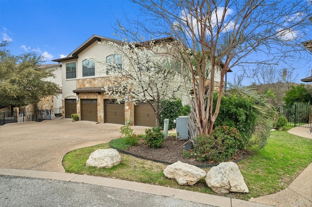 view of front of home with an attached garage, fence, stone siding, concrete driveway, and stucco siding