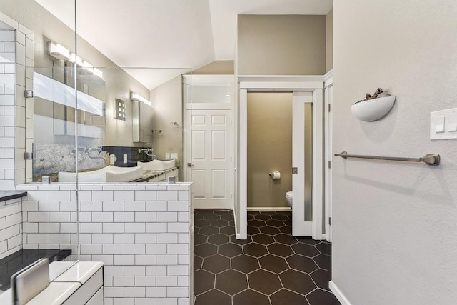 6303 Needham Ln, Austin, TX 78739 - full bath featuring vaulted ceiling, toilet, vanity, tile patterned floors, and a tile shower