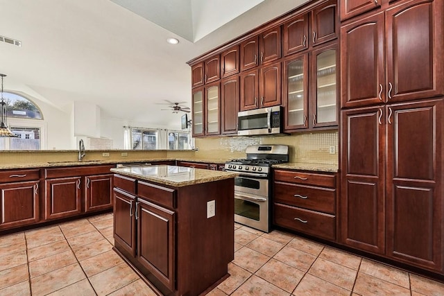 6303 Needham Ln, Austin, TX 78739 - kitchen featuring appliances with stainless steel finishes, a sink, light tile patterned flooring, light stone counters, and recessed lighting