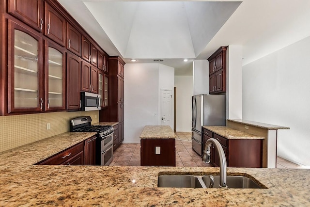 6303 Needham Ln, Austin, TX 78739 - kitchen with stainless steel appliances, light tile patterned floors, a sink, a kitchen island, and tasteful backsplash