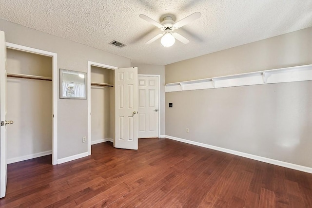 6303 Needham Ln, Austin, TX 78739 - unfurnished bedroom with multiple closets, a textured ceiling, wood finished floors, and baseboards
