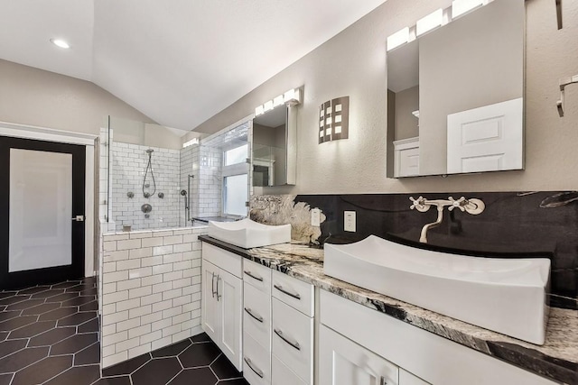 6303 Needham Ln, Austin, TX 78739 - bathroom featuring vaulted ceiling, double vanity, walk in shower, and tile patterned flooring