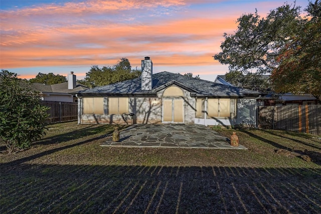 6303 Needham Ln, Austin, TX 78739 - back of property at dusk with a patio area and a chimney