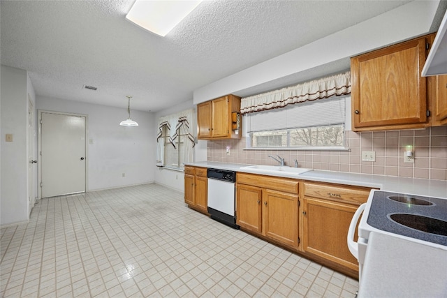 kitchen featuring white appliances, a sink, hanging light fixtures, light countertops, and brown cabinetry