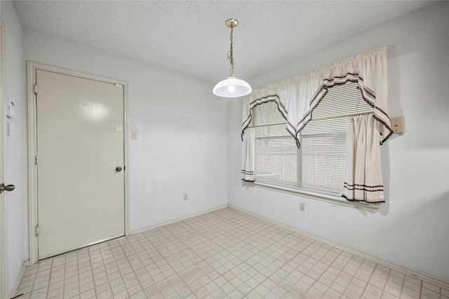 spare room with a textured ceiling and light floors