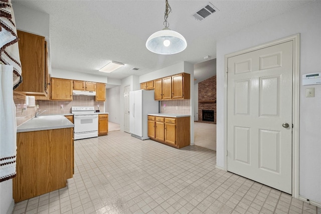 kitchen with hanging light fixtures, white appliances, visible vents, and light countertops