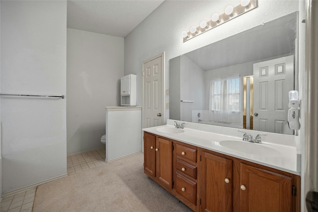 full bathroom featuring double vanity, a sink, and toilet