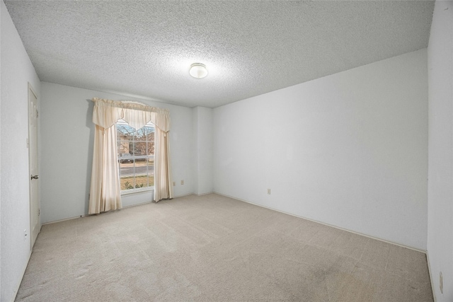 unfurnished room featuring light carpet and a textured ceiling