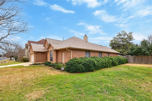 view of side of home with a lawn, a chimney, an attached garage, fence, and brick siding