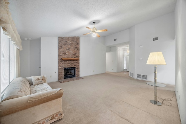 carpeted living room with a fireplace, visible vents, vaulted ceiling, a textured ceiling, and ceiling fan