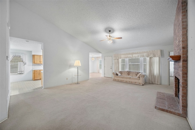 unfurnished living room with a brick fireplace, vaulted ceiling, a ceiling fan, and light colored carpet