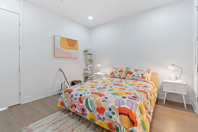 bedroom with baseboards, recessed lighting, and wood finished floors