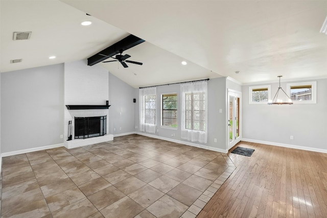 unfurnished living room with vaulted ceiling with beams, baseboards, a fireplace, and visible vents