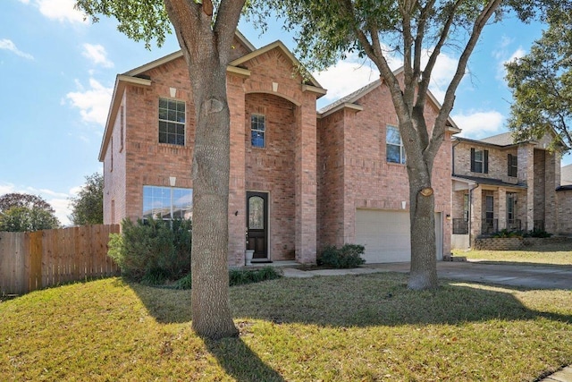 traditional-style house featuring brick siding, a front lawn, an attached garage, and fence