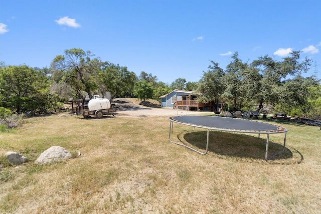 15001 Dexler Dr, Austin, TX 78734 - view of grassy yard with a trampoline, a deck, and view of wooded area