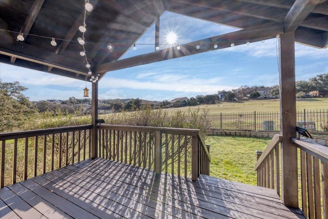 wooden terrace with a yard, a rural view, fence, and a gazebo