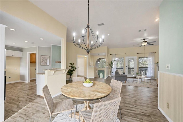 dining area with recessed lighting, visible vents, wainscoting, light wood-type flooring, and ceiling fan with notable chandelier