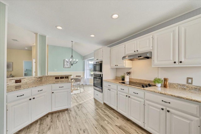 kitchen featuring black electric cooktop, under cabinet range hood, white cabinets, hanging light fixtures, and light wood finished floors