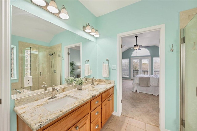 ensuite bathroom featuring double vanity, ensuite bathroom, tile patterned flooring, vaulted ceiling, and a sink