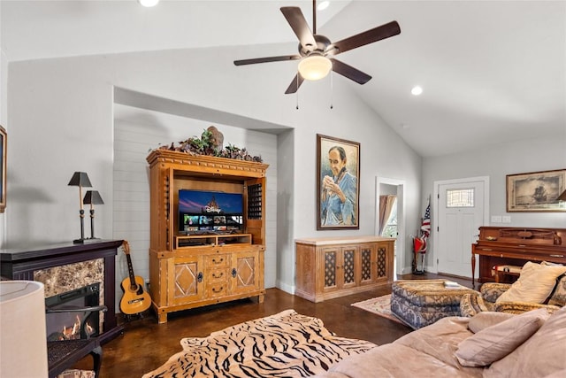 living room with baseboards, ceiling fan, finished concrete floors, vaulted ceiling, and a high end fireplace