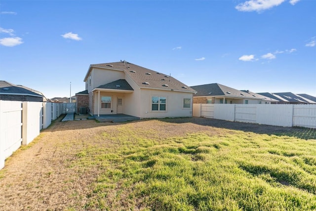 rear view of property with a yard, a patio area, a fenced backyard, and stucco siding