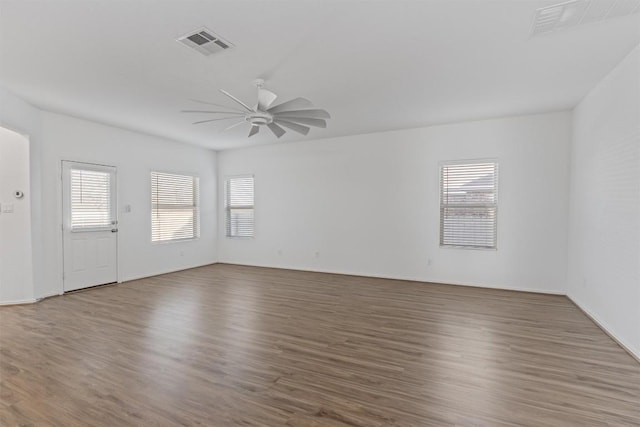 spare room featuring dark wood-type flooring, visible vents, and ceiling fan