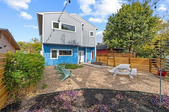 rear view of house featuring fence