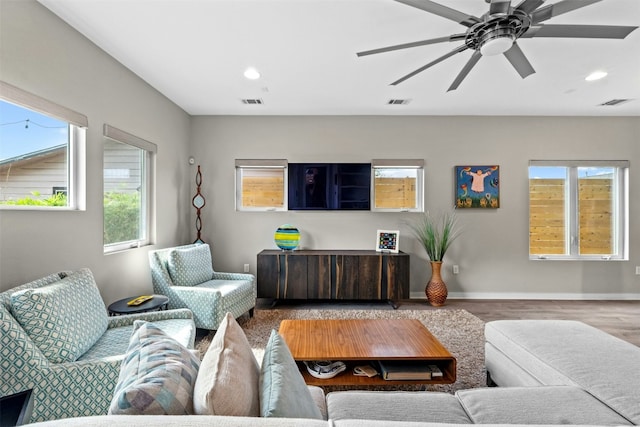 living area with visible vents, baseboards, wood finished floors, and recessed lighting