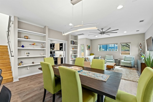 dining room with visible vents, a ceiling fan, wood finished floors, stairs, and recessed lighting