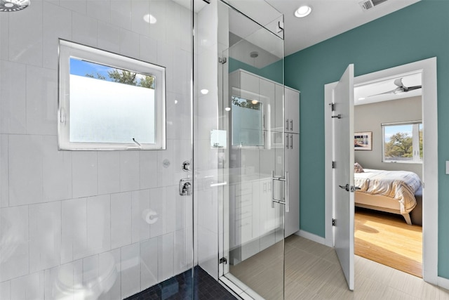 ensuite bathroom with ensuite bathroom, tile patterned flooring, a shower stall, and visible vents