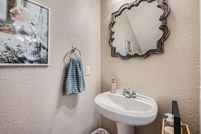 bathroom with a textured wall and a sink