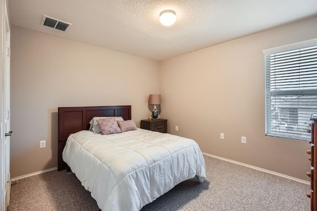 bedroom featuring a textured ceiling, multiple windows, carpet, and visible vents