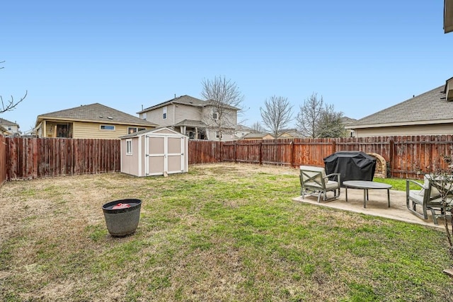 view of yard with an outbuilding, a storage unit, a patio area, and a fenced backyard