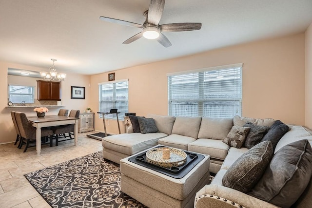 living room with light tile patterned floors and ceiling fan with notable chandelier