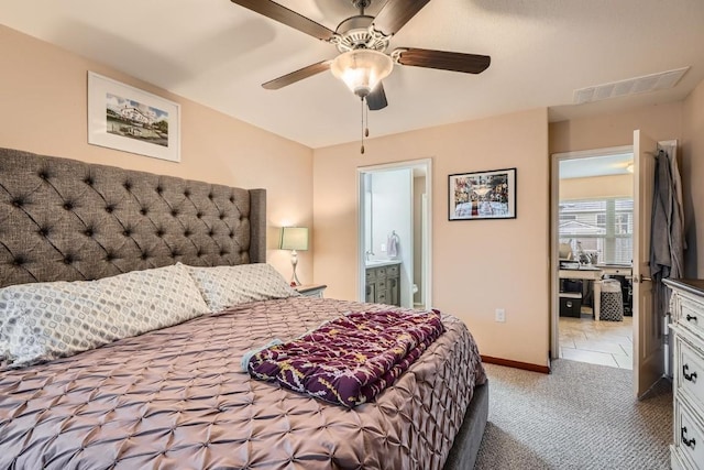 carpeted bedroom featuring ensuite bathroom, a ceiling fan, visible vents, and baseboards