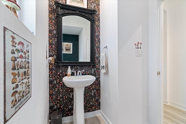 bathroom with baseboards and wood finished floors