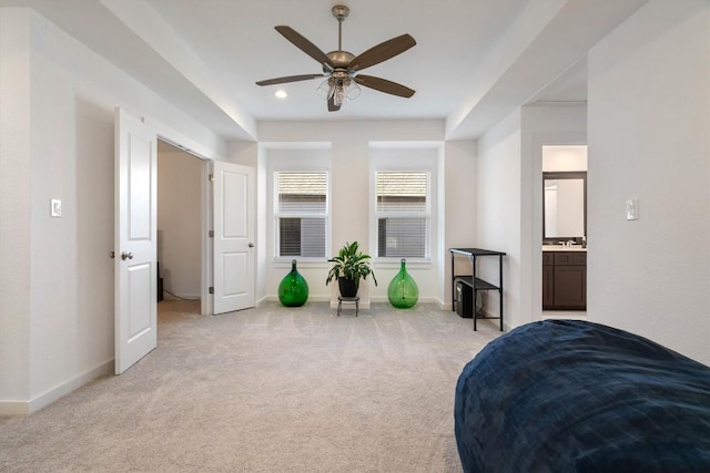 bedroom featuring a ceiling fan, light colored carpet, a sink, and baseboards