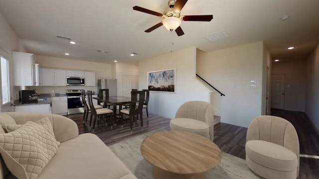 living area with light wood-style floors, ceiling fan, visible vents, and recessed lighting