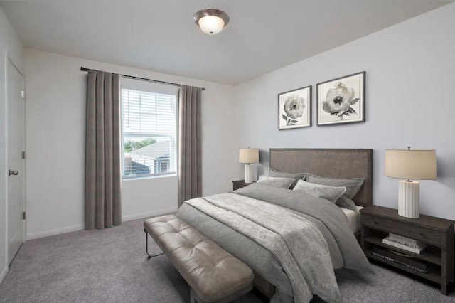 bedroom with baseboards and light colored carpet