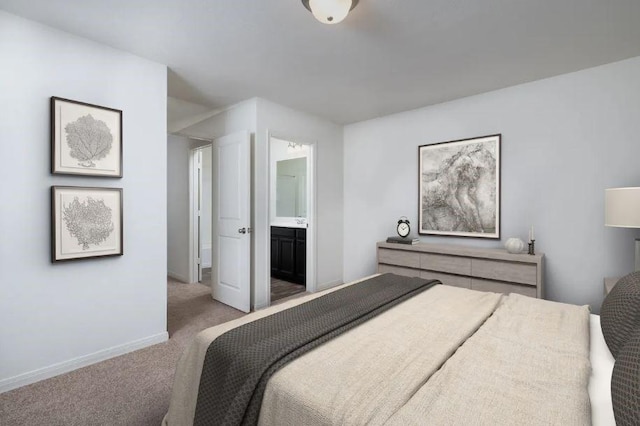 bedroom with baseboards, connected bathroom, and light colored carpet