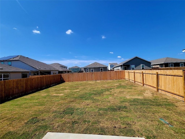 view of yard with a fenced backyard and a residential view