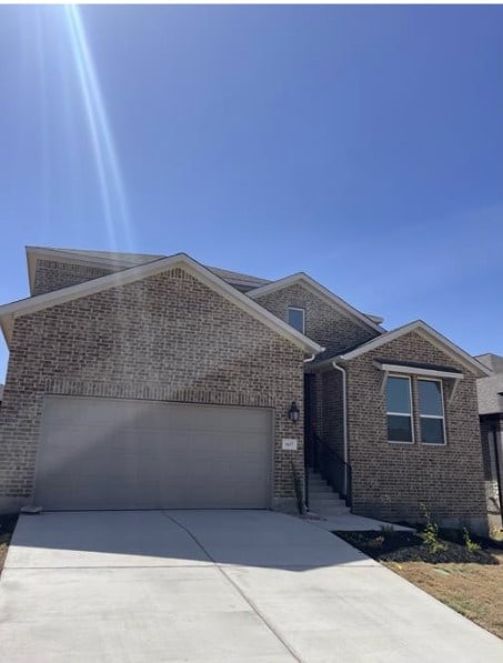 ranch-style house with brick siding, driveway, and a garage