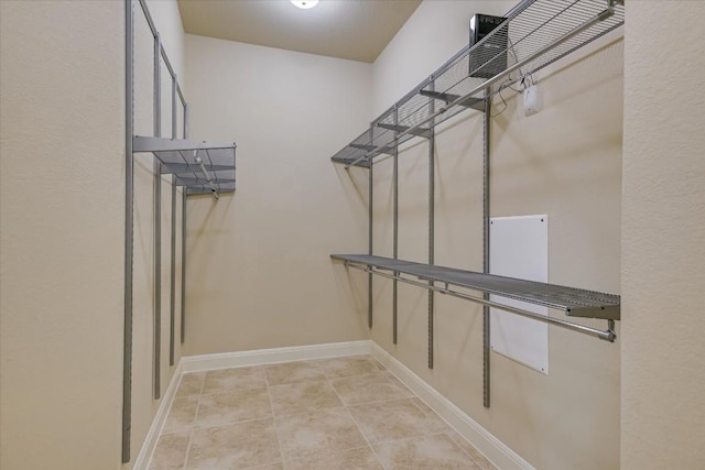 spacious closet with light tile patterned floors